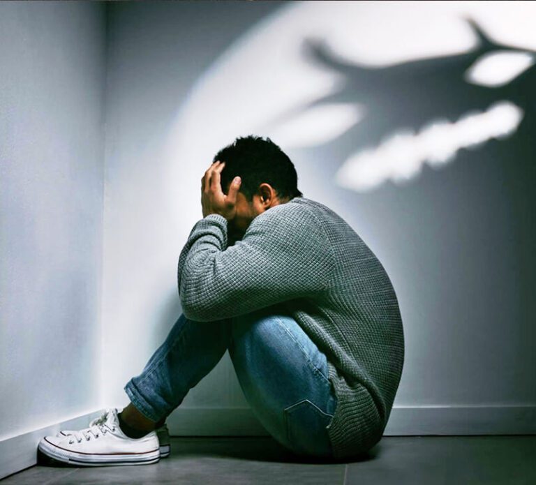 young-man-sitting-corner-dark-room-with-scary-figure-wall